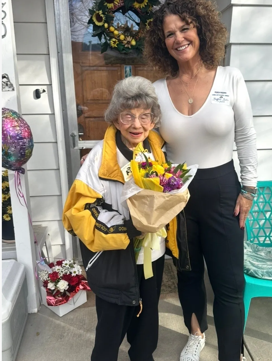 Peach Pagano sharing a moment with a beloved client holding a fresh bouquet